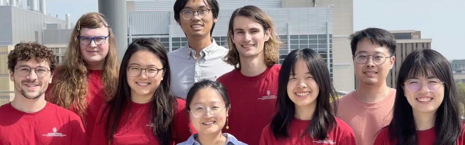 Lab members Fall 2025 smiling at the camera wearing matching red shirts.